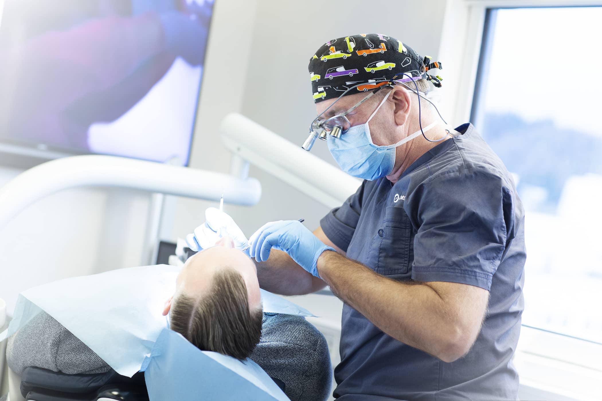 Tannlege Paul Arne Hordvik jobber med å gi Anders i tannlegestolen nye tenner.